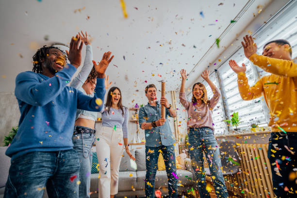 istock Friends throwing confetti during party at home 1406232320