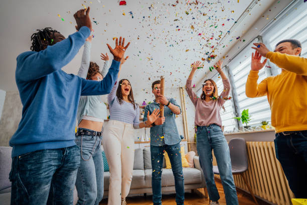 istock Friends throwing confetti during party at home 1406232336
