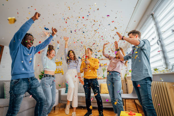 istock Friends throwing confetti during party at home 1406232355