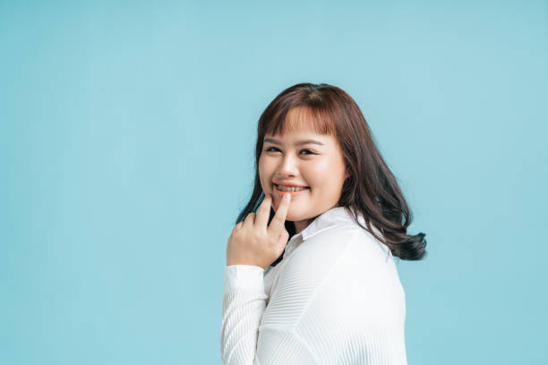 istock Portrait beautiful confidence Asian woman plus size happy smile on isolate light blue studio background. 1406232430