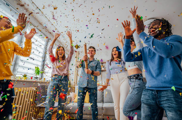 istock Friends throwing confetti during party at home 1406232986