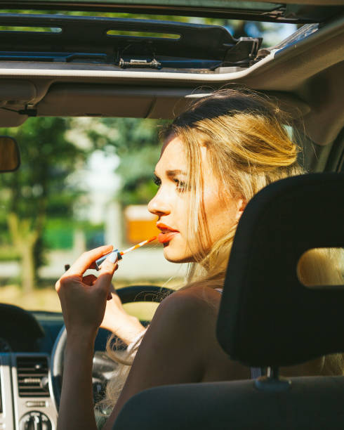 istock Girl apply make up while driving car. 1406233177
