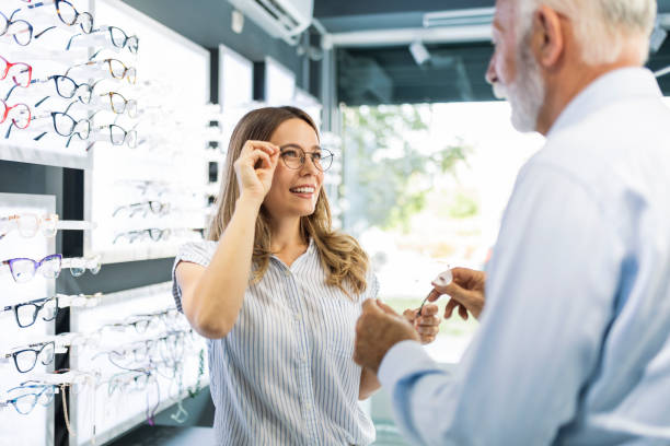 istock Senior man in optic store showing eyewear to a customer 1406233762