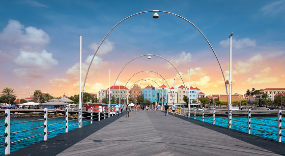 Pontoon bridge across St. Anna Bay that connects the Punda and Otrobanda quarters of the capital city, Willemstad, Curacao, Netherlands Antilles. ABC Islands, Caribbean. Colorful buildings, bridge and beautiful sky.