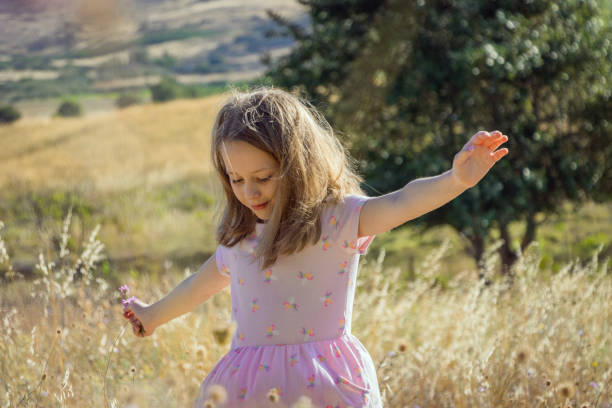istock Young girl dancing in a country field 1406235577