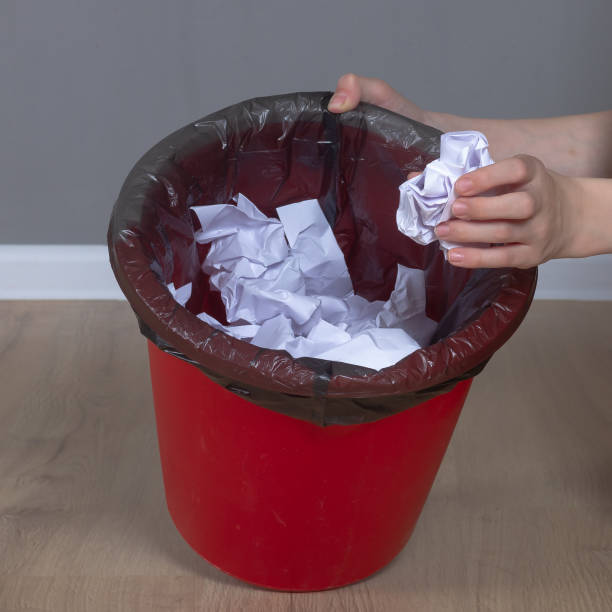 istock Throw crumpled paper in a red trash can 1406235619