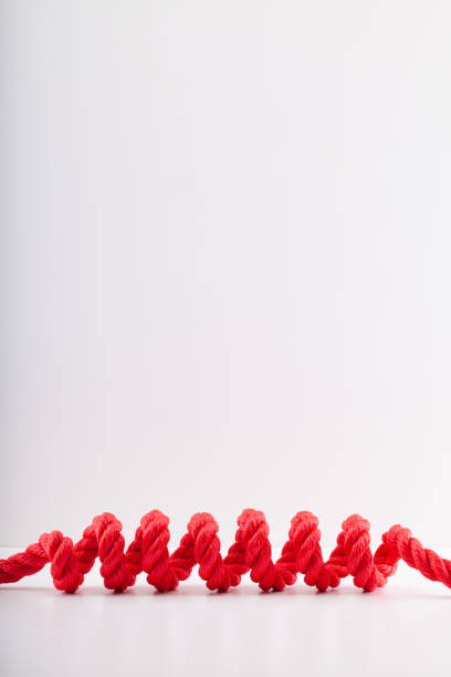 corda rossa con una spirale isolata su sfondo bianco. - rope frayed breaking tied knot foto e immagini stock