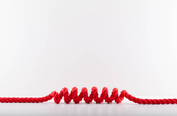 красная веревка со спиралью выделена на белом фоне. - rope frayed breaking tied knot стоковые фото и изображения