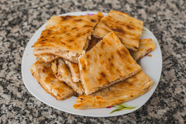 Turkish style cheese stuffed filo dough borek served su boregi. Slices of pastries in the serving plate.