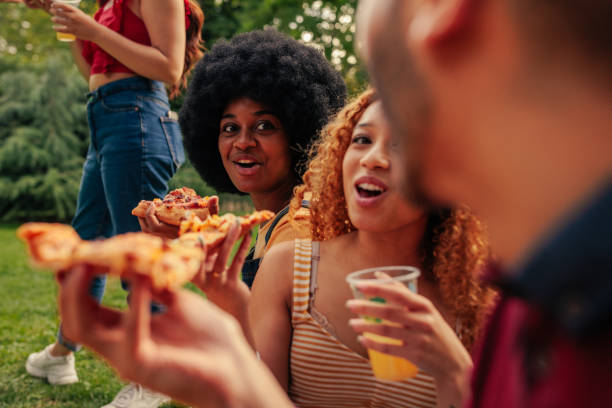 istock Friends having pizza in park 1406242396