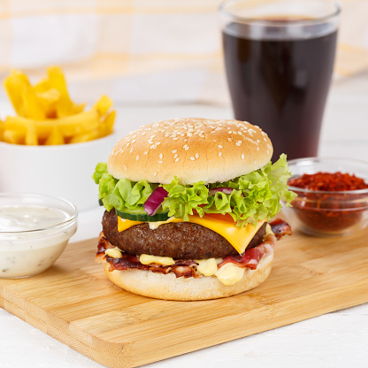 Hamburger Cheeseburger meal fastfood fast food with cola drink and French Fries on a wooden board square menu