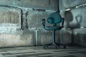 istock The interrogation chair. An old chair in a concrete basement. 1406244695