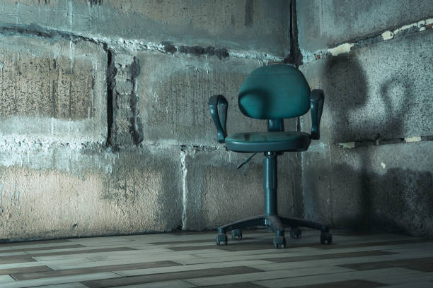 The interrogation chair. An old chair in a concrete basement. stock photo