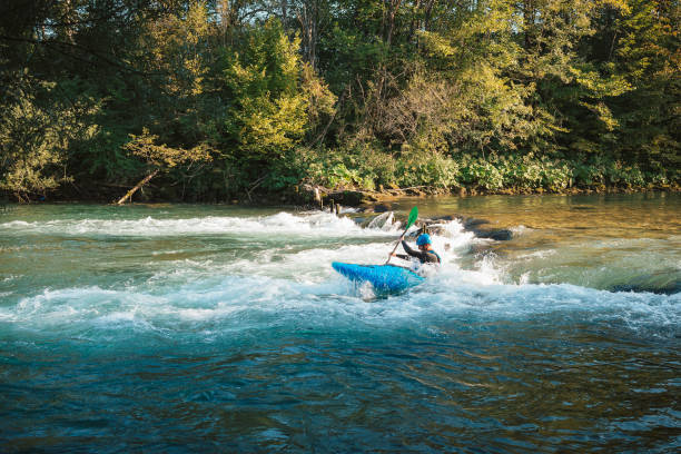 istock Man cruising down whitewater rapids in a kayak 1406244767