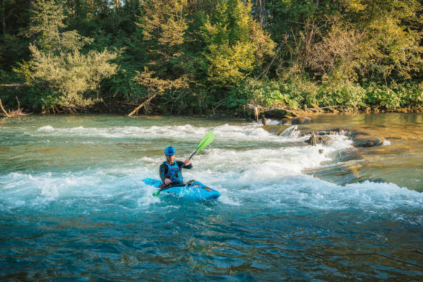 istock Man cruising down whitewater rapids in a kayak 1406244793