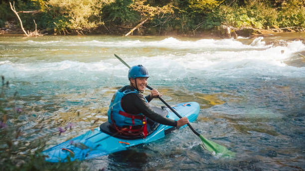 istock Man cruising down whitewater rapids in a kayak 1406244796