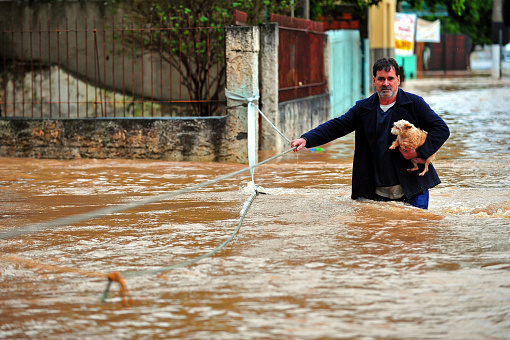 Gravatai, Rio Grande do Sul, Brazil - Jul 14th, 2015: Man rescuing a dog in the flood