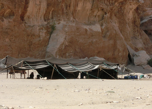 tents of a small camp of a nomadic tribe near the Rocks in the desert of sand