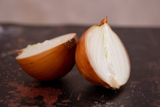 istock A halved onion on a black metal surface background. 1406251281
