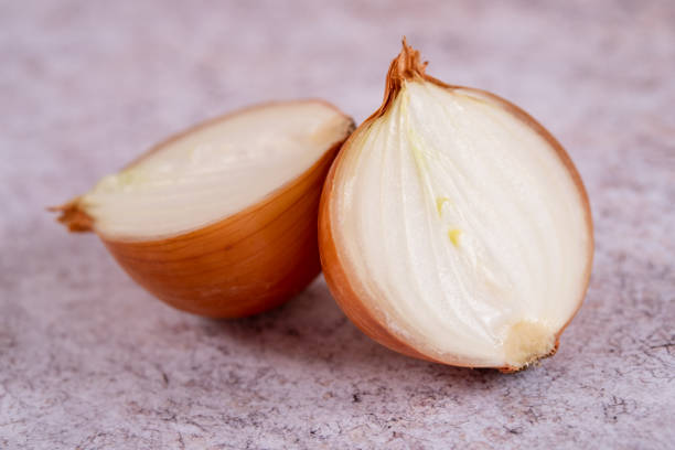 istock A halved onion on a white stone surface background. 1406251351
