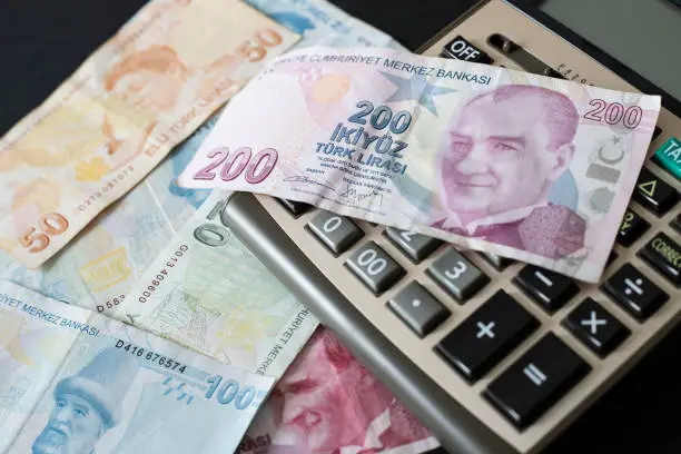 Photo of Turkish Liras and calculator on black background.