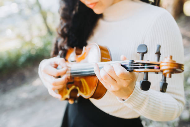 istock unrecognizable curly brunette woman doing pizzicato technique in violin. Selective focus. 1406252654