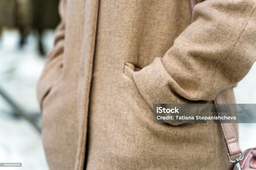 Hands in pockets of coats of bezel color made of wool Coat - Garment Stock Photo