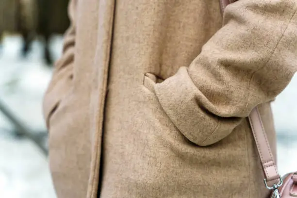 Photo of Hands in pockets of coats of bezel color made of wool