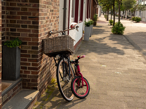 Bicycle with a wicker basket. Bicycles against the wall.