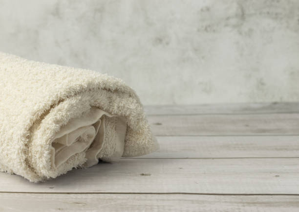 istock Rolled towels on wooden table in bathroom, white 1406255677