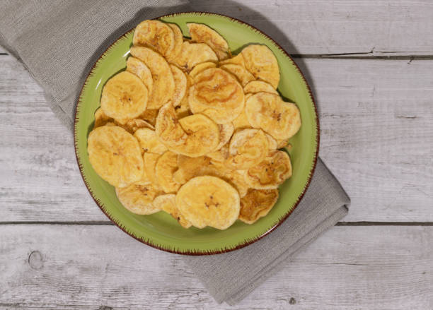 istock Fried plantain on green plate and white wooden table, overhead view 1406255709