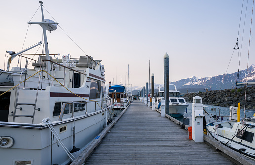 Seward, Alaska, USA - June 13, 2022:Pier in the port city of Seward, Alaska,Fishing and pleasure boats docked in Seward Harbor .