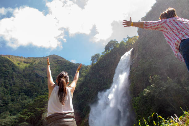 istock Mom and daughter watching a waterfall and feeling happy 1406258077