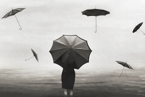 surreal woman with umbrella in the rain with flying black umbrellas around