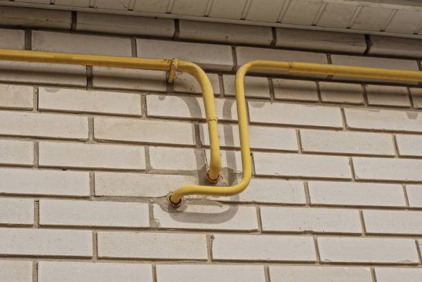 istock yellow metal gas pipes on a white brick wall 1406262588