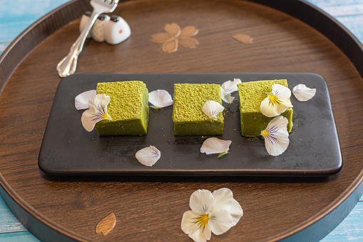 Nama Matcha Chocolate With Edible Flowers on a Traditional Wooden Tray. Image can be utilized editorially or commercially.