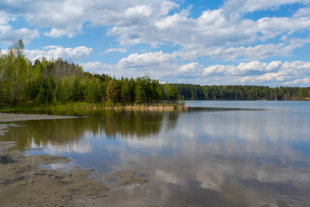 istock Scenic view at beautiful spring day on a forest lake. Deep blue cloudy sky and forest on a background, spring landscape. 1406268600