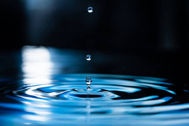 Drops of water fall onto the water surface