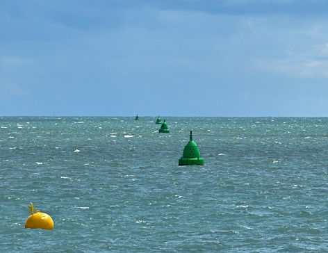 Green marker buoys form a line