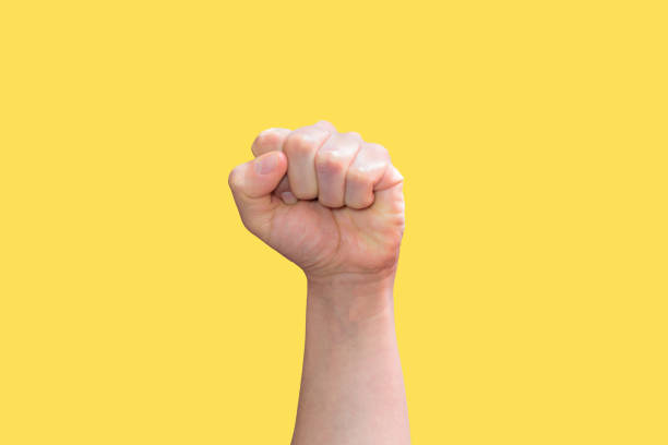 istock White hand with a clenched fist on a yellow background 1406271665