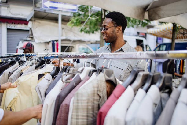 istock Two men shopping clothes from a rack at a flea market 1406272619