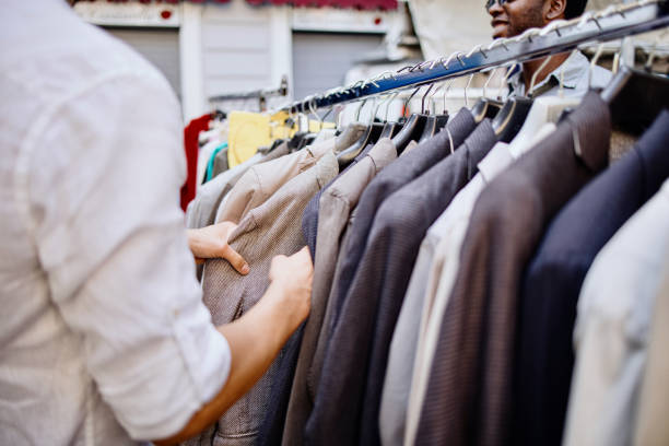istock Two men shopping clothes from a rack at a flea market 1406272747