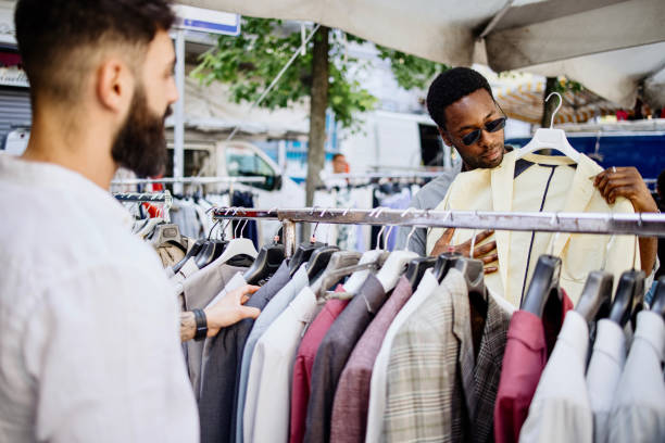 istock Two men shopping clothes from a rack at a flea market 1406272833