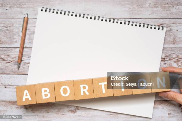 Wooden Blocks With Abortion Text Of Concept A Pen And A Notebook Stock Photo - Download Image Now