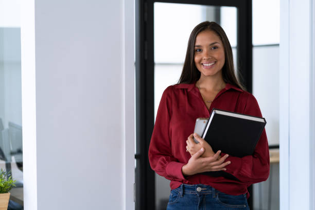 Young latin  woman working in the office looking at camera smiling stock photo
