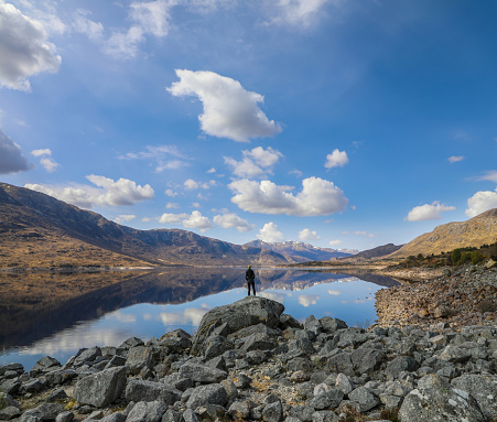 Panoramic view of a perfect lake reflection of clouds and mountains in Dundreggan Reservoir in Northern Scotland