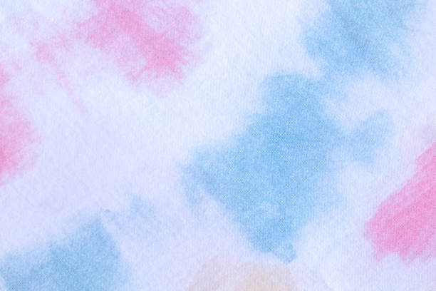 Pink and blue hand made tie die pattern on white textile.