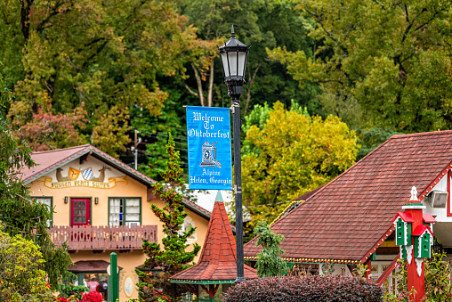Helen, USA - October 5, 2021: Bavarian village of Helen, Georgia with houses buildings on main street traditional alpine architecture with Oktoberfest banner on lamp post