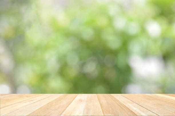istock Empty top wooden table on defocused abstract bokeh blurred green nature for background 1406285462