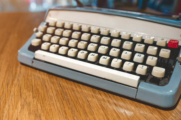 istock Retro old typewriter on blur background and front of wooden table. Vintage concept, selective Focus. 1406287350